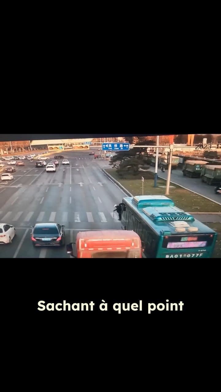 Un passant porte un homme âgé pour traverser la route