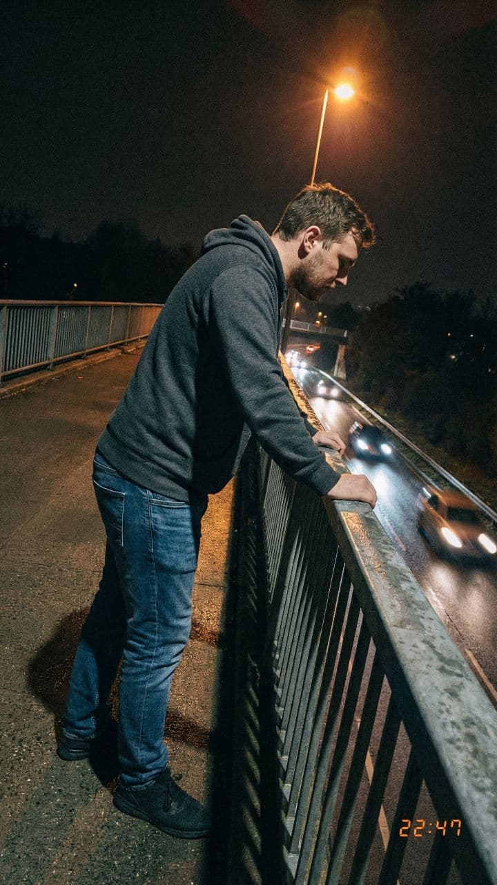 Man Steps Back From Bridge Railing